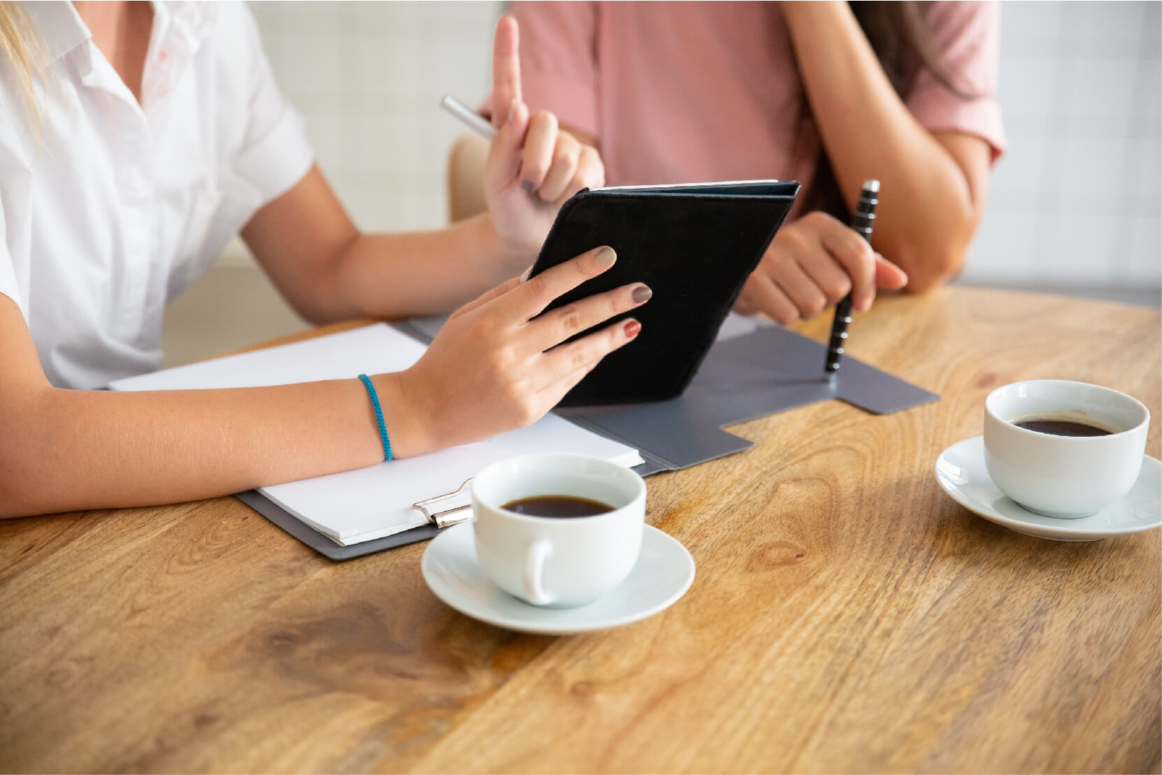 Business ladies meeting table watching presentation tablet discussing project deal